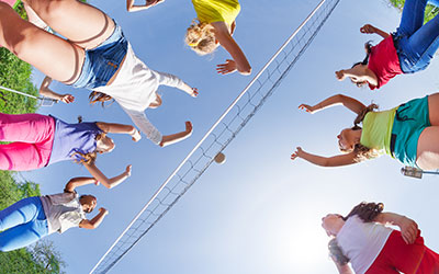 several volleyball players jumping for the ball