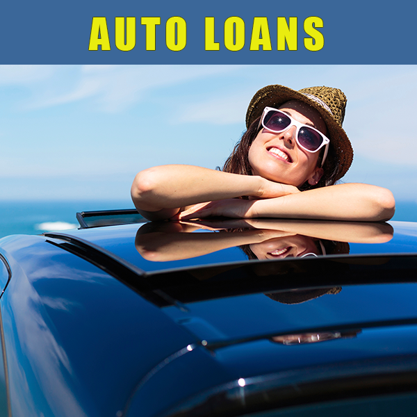 laughing young woman with her head out the back window of a car.