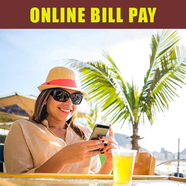 Young woman paying her bills at the beach.