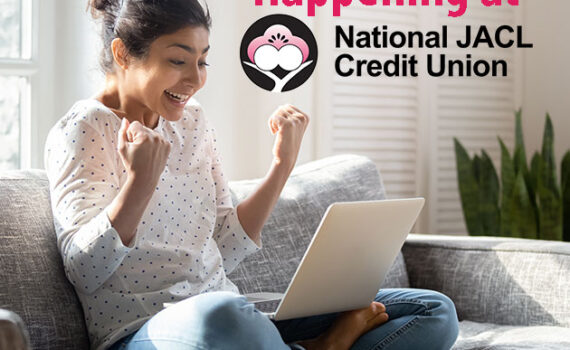 Young woman celebrating with raised hands while looking at her laptop